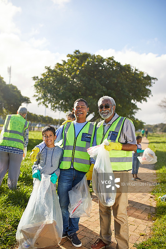 肖像快乐的多代人志愿者，清理垃圾在阳光公园图片素材