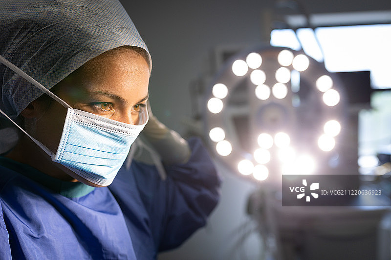 在手术室里，一位白种女外科医生在手术前戴着医用口罩图片素材