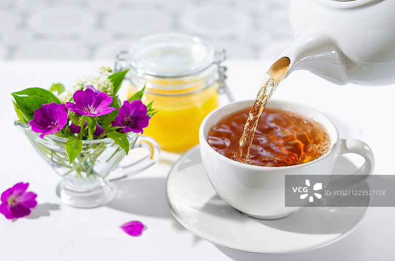 白底薄荷蜂蜜热茶:倒茶过程的选择焦点图片素材