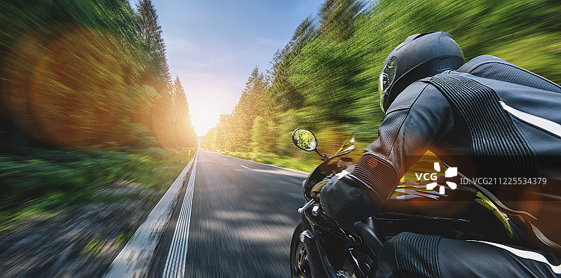 摩托车在路上开得很快。在空虚的高空享受乐趣图片素材
