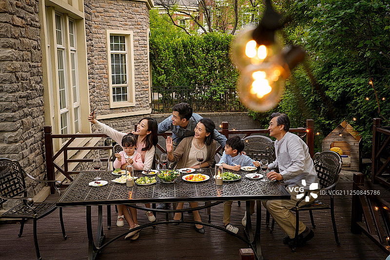 快乐大家庭在庭院里用餐图片素材