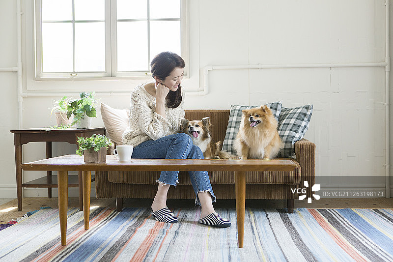 中年妇女和狗坐在沙发上图片素材