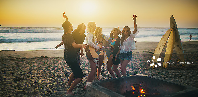 一群冲浪者朋友在海滩派对上跳舞和演奏音乐，圣地亚哥，加利福尼亚，美国图片素材
