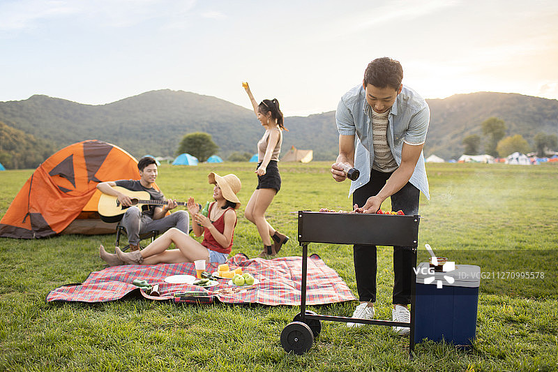 快乐的年轻朋友在户外野餐图片素材
