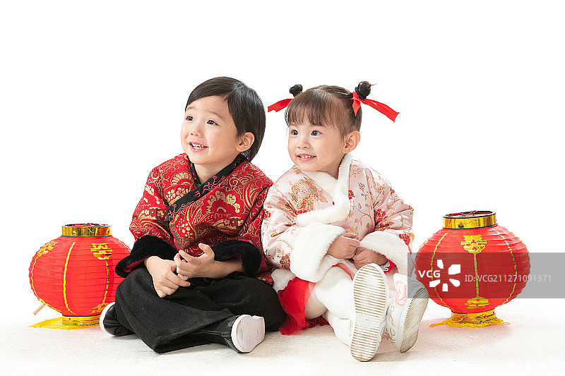 庆祝新年的两个小朋友坐在地上玩耍图片素材