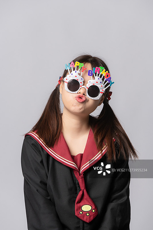穿着JK水手制服的女孩带着生日眼镜图片素材