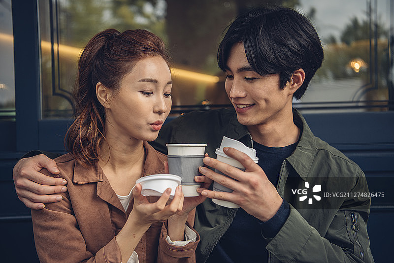 夫妻坐在商店前喝咖啡的照片图片素材