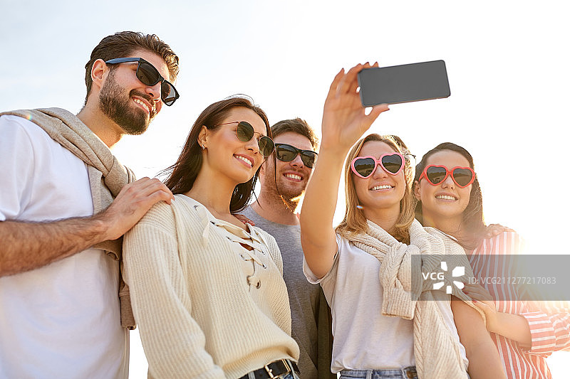 友谊、休闲和人的概念——一群快乐的朋友在夏天用智能手机自拍。快乐的朋友在夏天自拍图片素材