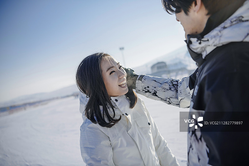 一对情侣在滑雪场的雪地上互相凝视的照片图片素材