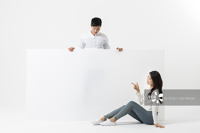 男人站在后面，女人坐在白色空白横幅的姿势图片素材