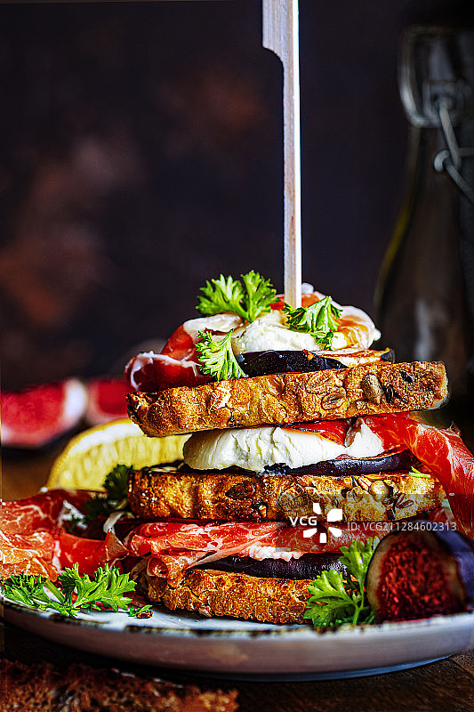荷兰，堆叠在盘子里的三明治与羊奶酪，无花果和火腿的特写图片素材