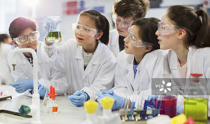 好奇的学生在实验室教室进行科学实验，检查烧杯中的液体图片素材