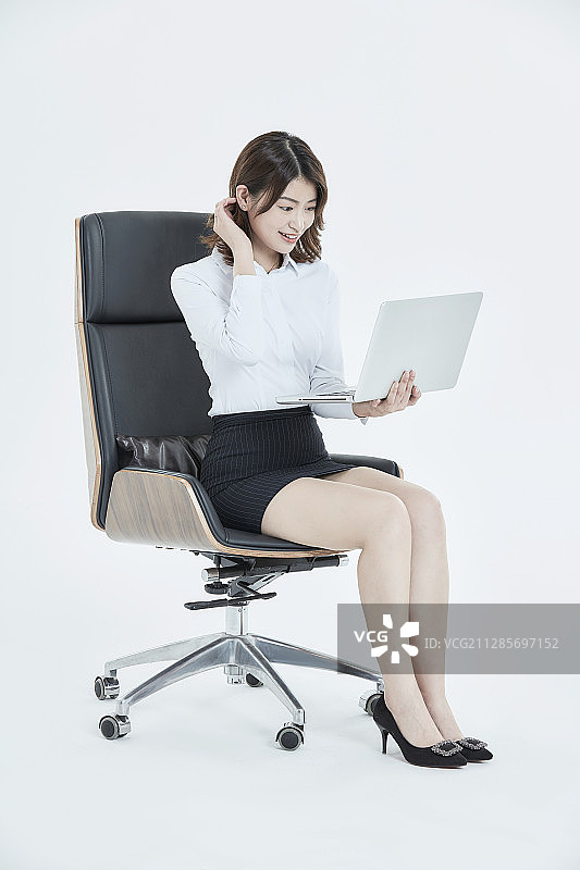 坐在办公椅上的白领女性使用电脑图片素材