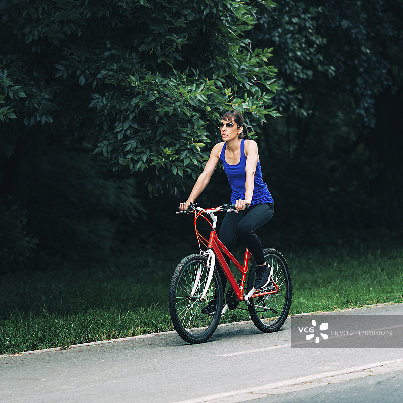 在公园里骑自行车的女人图片素材