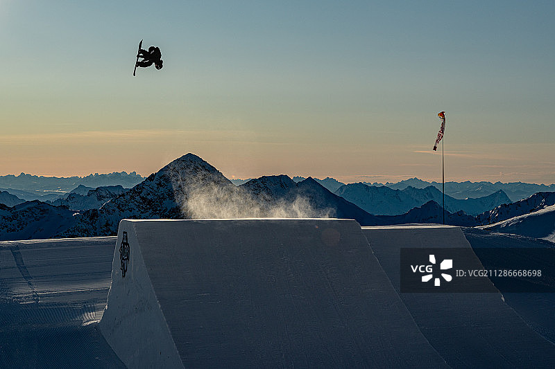 在奥地利山脉的日出期间，滑雪运动员飞得很高图片素材