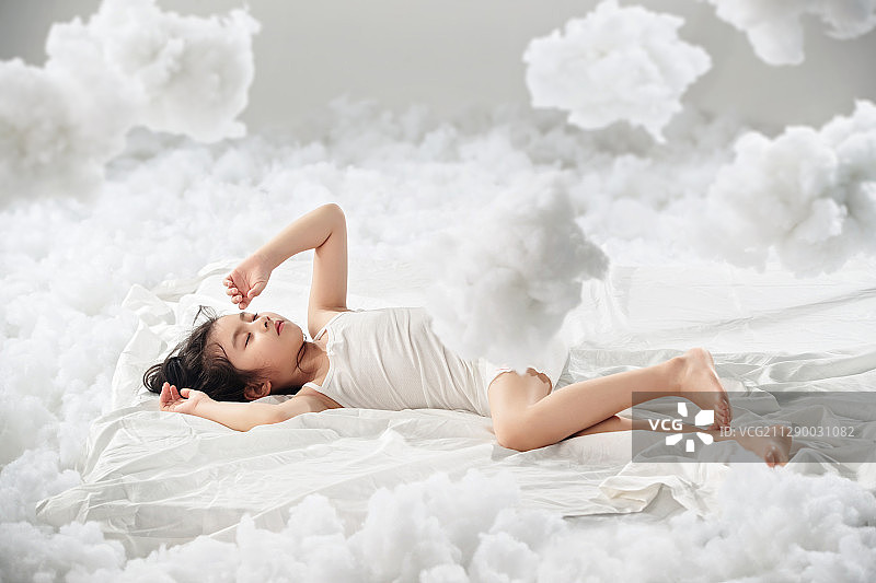 可爱的小女孩躺在云朵上图片素材