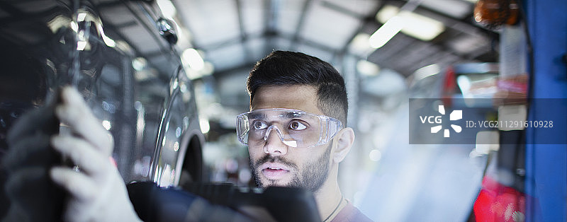 专职男性机械师在汽车修理厂检查汽车图片素材