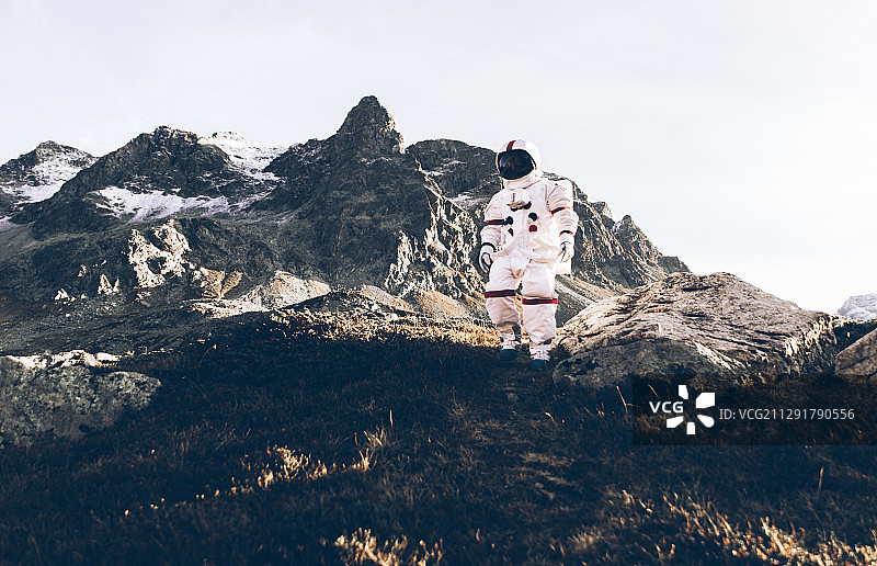 宇航员穿着太空服在山上行走图片素材