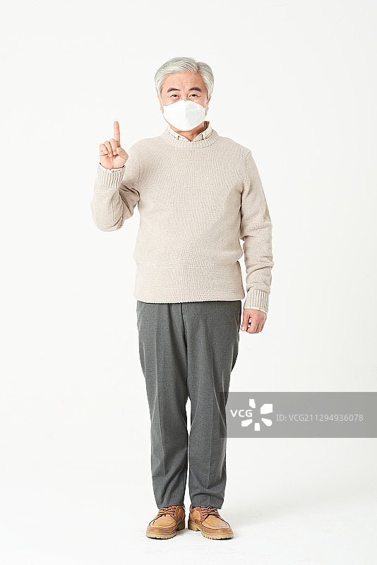 戴着污染口罩的老人举着手势站着图片素材