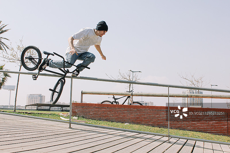 西班牙塔拉戈纳，晴空下，年轻人在自行车上表演特技图片素材