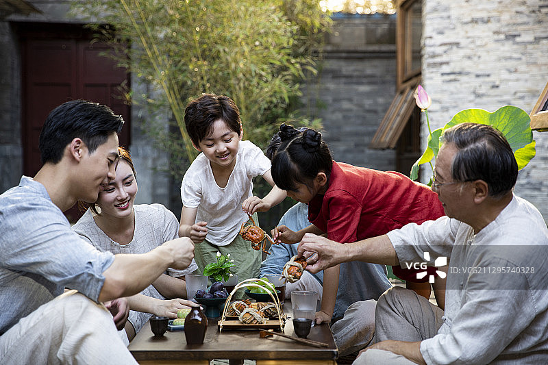 中秋节一家六口在户外庭院聚餐吃大闸蟹图片素材