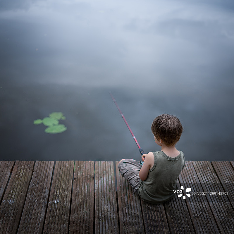 在湖里钓鱼的男孩图片素材
