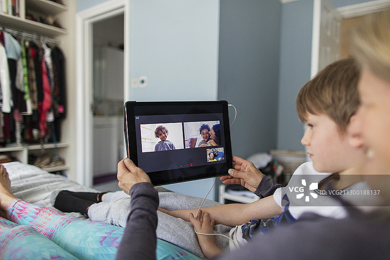 家庭视频聊天与数字平板电脑在床上图片素材