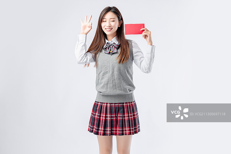 身穿校服,手里拿着红包的亚洲女孩图片素材