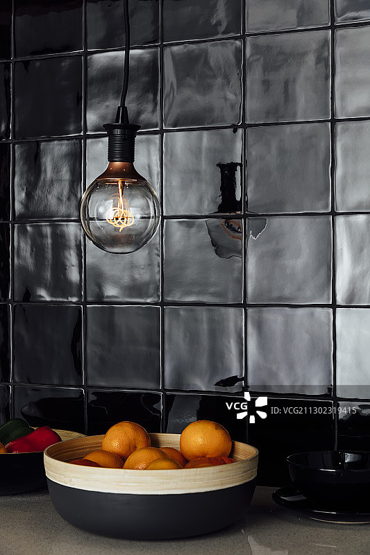黑色瓷砖厨房柜台上的橘子图片素材