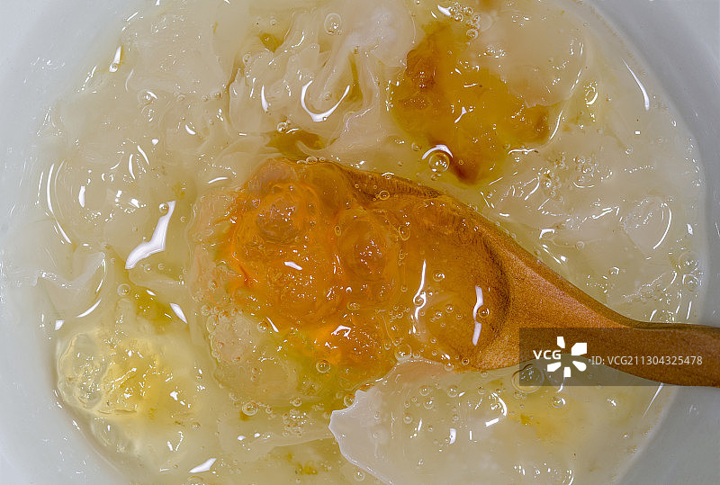 木勺舀起熬煮好的桃胶皂角米银耳羹图片素材