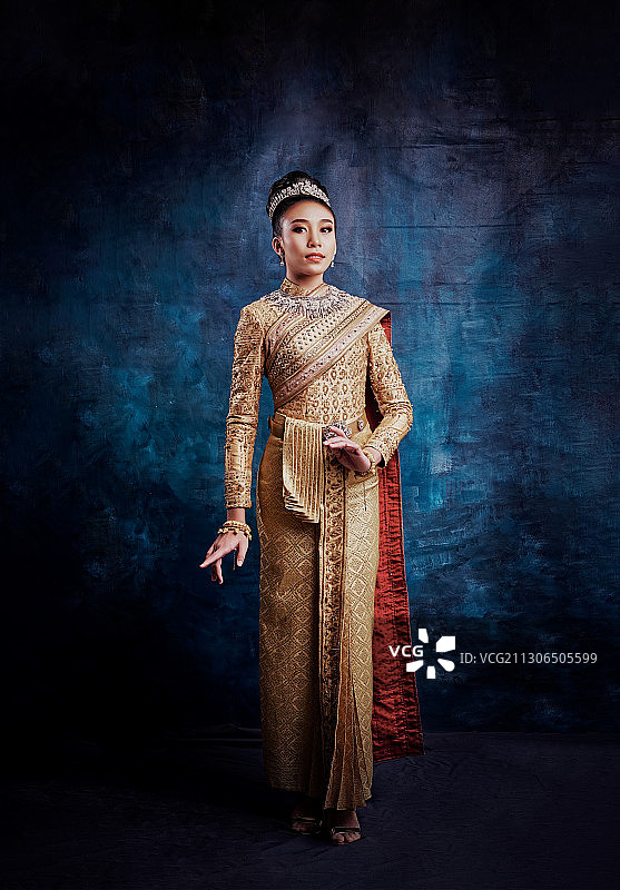 泰国清迈，身穿传统服饰的少女全身靠墙站立图片素材