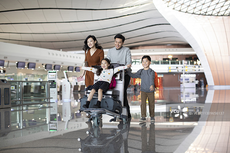 快乐的年轻家庭在机场准备出发去旅行图片素材