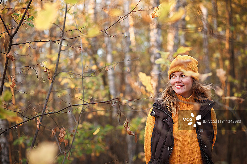在俄罗斯的秋天，一个女人站在森林里图片素材