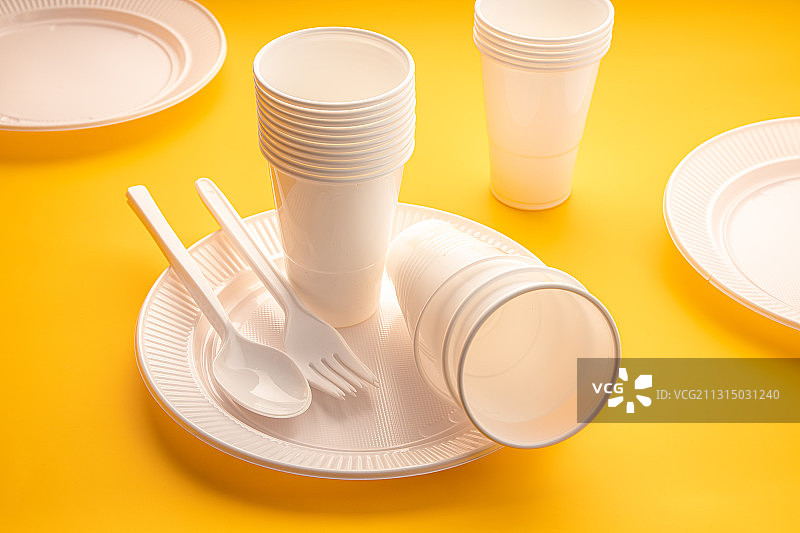 黄色背景上的餐具和盘子的高角度视图图片素材