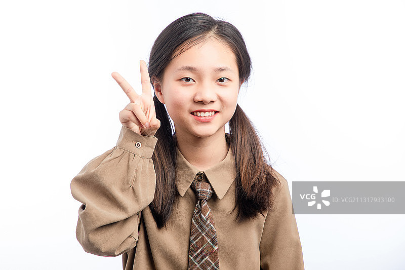 白色背景里，举着剪刀手手势的亚洲小女孩图片素材
