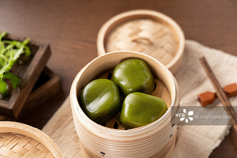 中国传统饮食文化早茶早餐蒸笼上的可口青团艾糍饼图片素材