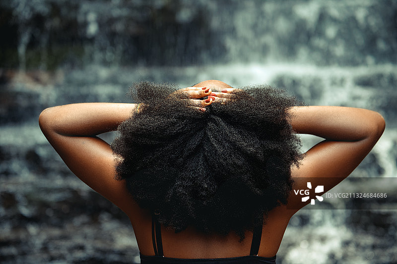一个年轻的非洲黑人妇女在加纳的一个瀑布图片素材