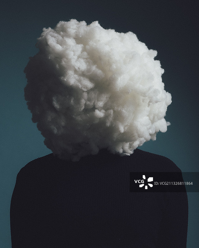 一个人在工作室的特写肖像，用棉花覆盖的脸代表一朵云，巴黎，法国图片素材