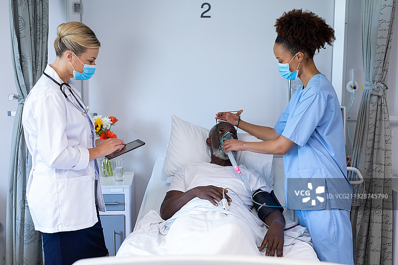 混血女医生戴口罩给男病人戴上氧气面罩图片素材