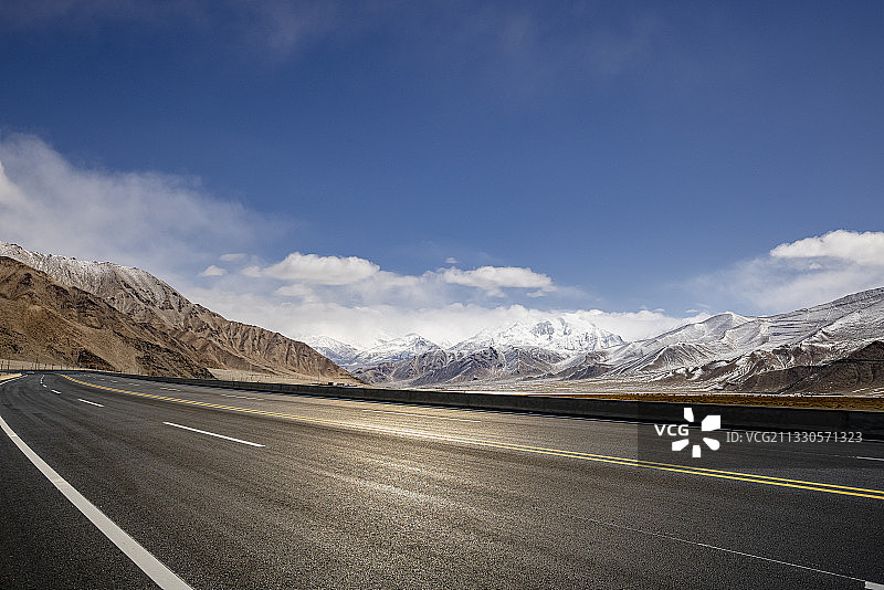 新疆雪山前的动感柏油路图片素材