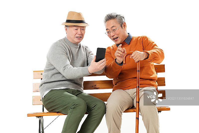 两位老年朋友坐在长椅上看手机图片素材