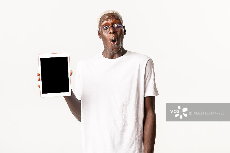 高级男子的肖像拿着数字平板电脑，而站在白色的背景图片素材