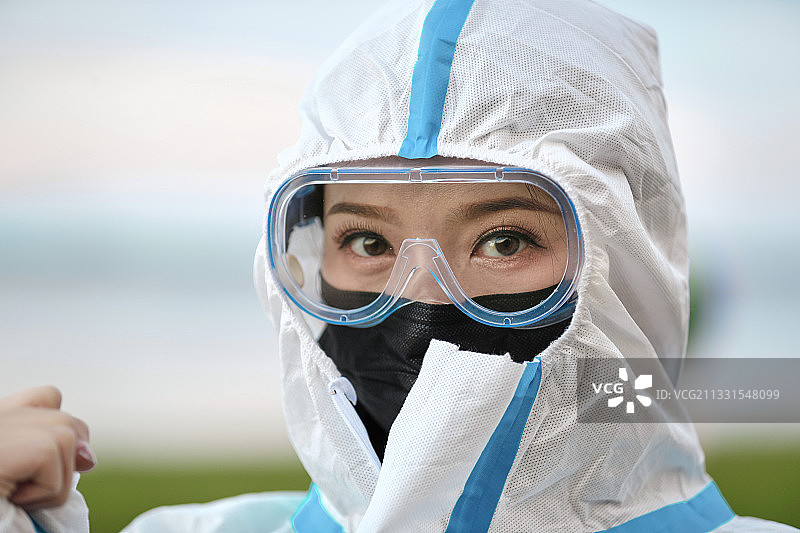 穿白色防护服佩戴护目镜口罩的女性防护人员图片素材