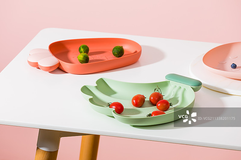 桌子上的彩色塑料水果盘图片素材