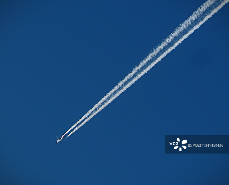 飞机在晴朗的蓝天下飞行的低角度视图图片素材