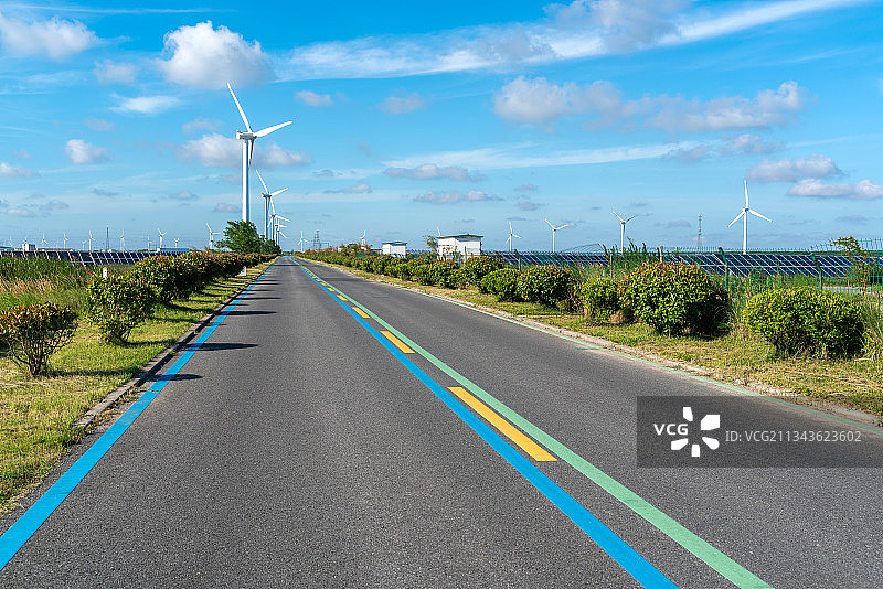 公路两侧的太阳能电池板和风力发电机图片素材