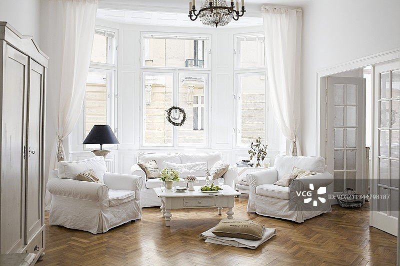 时代公寓客厅飘窗吊灯下的白色松套沙发和茶几图片素材