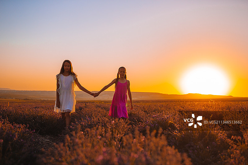 母亲和女儿在日落的田野里图片素材