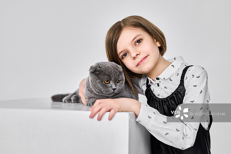 一个白人小女孩抱着她的猫图片素材
