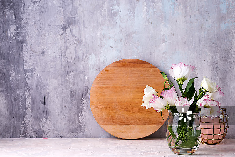 靠着墙的桌子上花瓶里的Eustoma花的特写图片素材